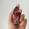Trụ đá Tường Vi Rhodonite đỏ trên tay